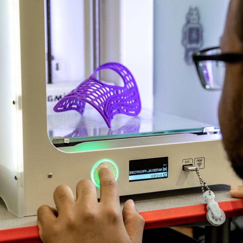 A person uses a 3D printer.